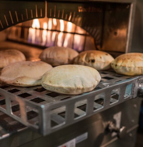 Pita breads baking at the oven